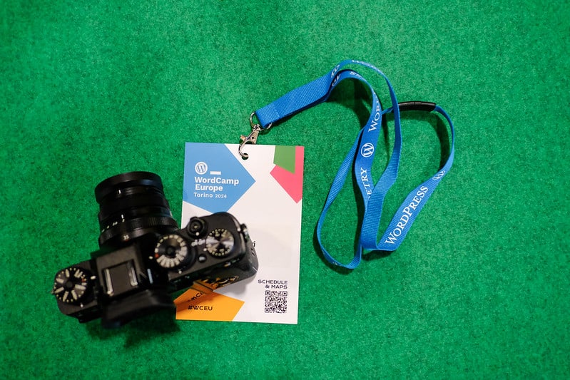 Photo of a camera on a WordCamp Europe 2024 name bade.